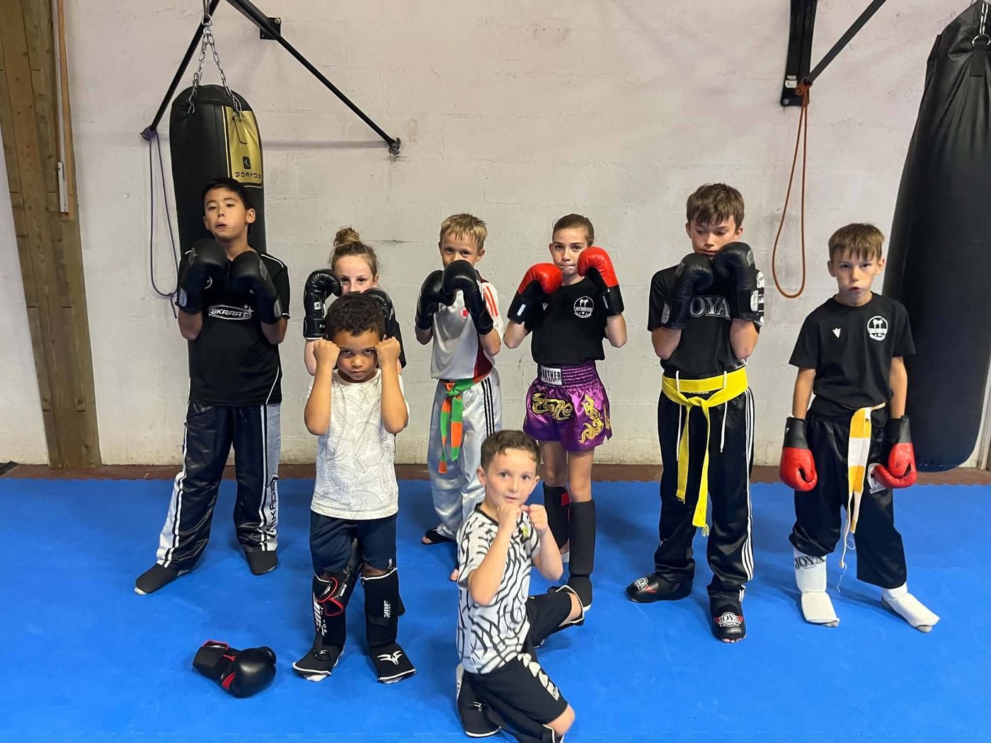 Les enfants du club posent ensemble, gants aux poings